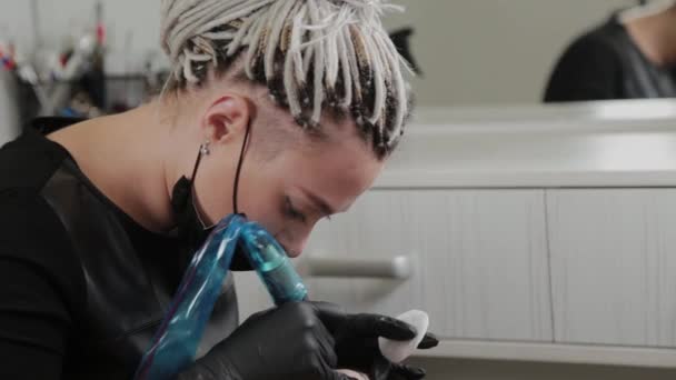 Un artista de maquillaje permanente profesional hace maquillaje de cejas permanente con una máquina de tatuaje . — Vídeo de stock