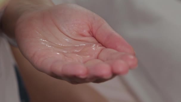 Mujer masaje terapeuta vierte aceite de masaje en la mano . — Vídeos de Stock