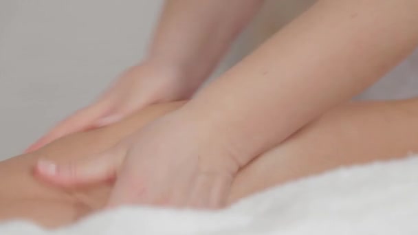 Woman massage therapist does massage on the legs of a young girl. — ストック動画