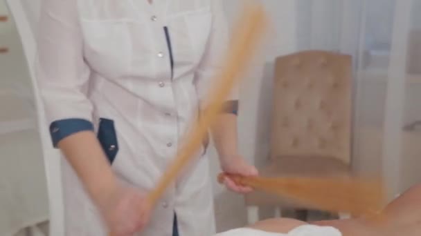 Женщина-массажист делает массаж с бамбуковыми палочками для молодой девушки . — стоковое видео