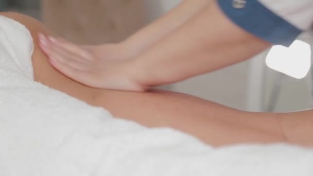 Mulher massagem terapeuta faz massagem nas pernas de uma jovem . — Vídeo de Stock