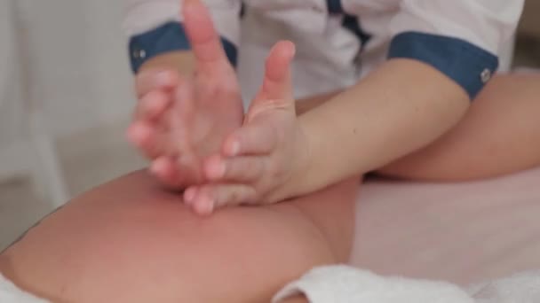 Vrouwelijke massage therapeut doen massage over de gehele lengte van de benen van een jong meisje. — Stockvideo