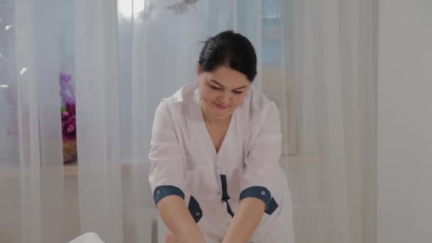 Γυναίκα θεραπεύτρια μασάζ κάνει μασάζ στους μυς των μόσχων ενός νεαρού κοριτσιού. — Αρχείο Βίντεο