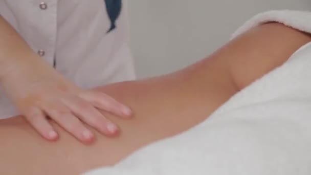 Donna massaggiatrice fa massaggio al miele ad una giovane ragazza in un salone di massaggio . — Video Stock