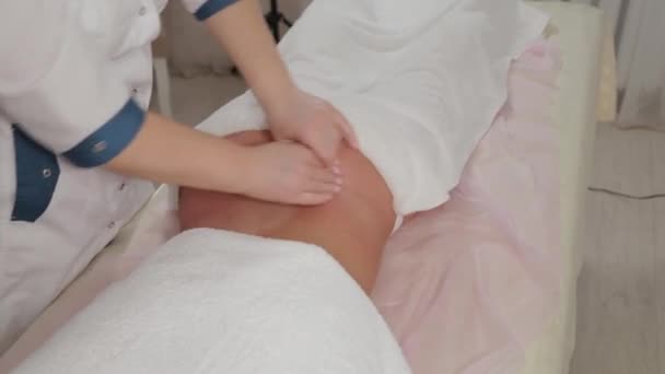 Mujer terapeuta de masaje haciendo masaje en los lados de una chica joven en un salón de masajes . — Vídeos de Stock