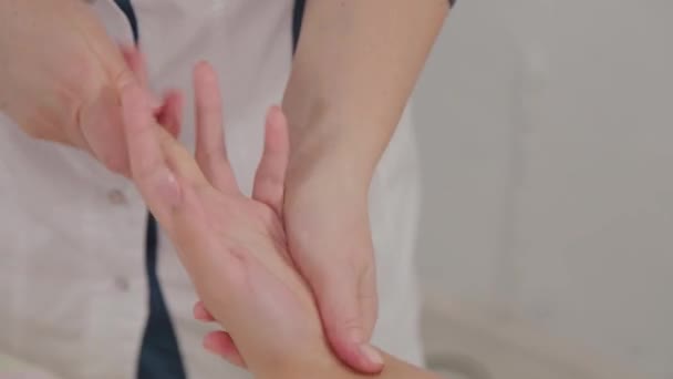Женщина-массажист делает массаж всей руки молодой девушке в массажном салоне . — стоковое видео