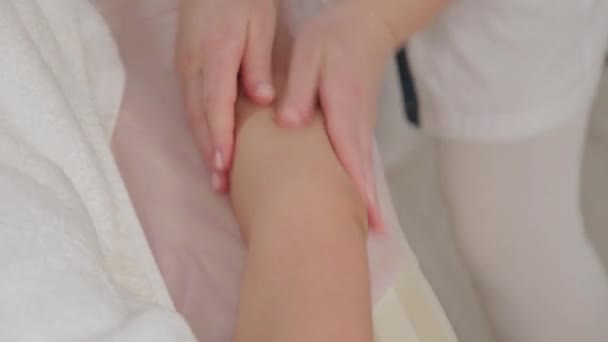 Жінка масажистка робить масаж на всю руку молодій дівчині в масажному салоні . — стокове відео