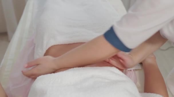 Γυναίκα θεραπεύτρια μασάζ κάνει μασάζ στο στομάχι ενός νεαρού κοριτσιού. — Αρχείο Βίντεο