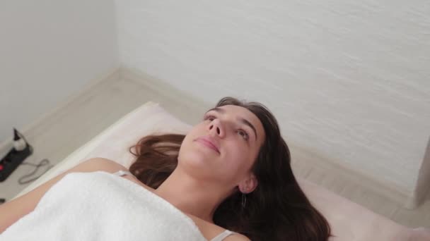 Vacker ung flicka på en soffa i en skönhetssalong. — Stockvideo
