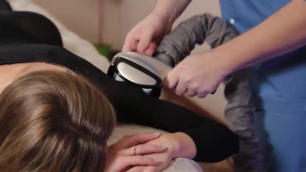 Professional male masseur makes a vacuum massage with a special device to a beautiful woman. — Stock Video