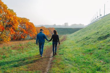 Birbirini seven çiftler sonbaharda sokakta yürürler..