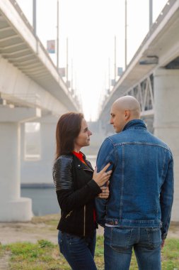 Mutlu aşıklar güneşli bir günde köprünün altında durur.