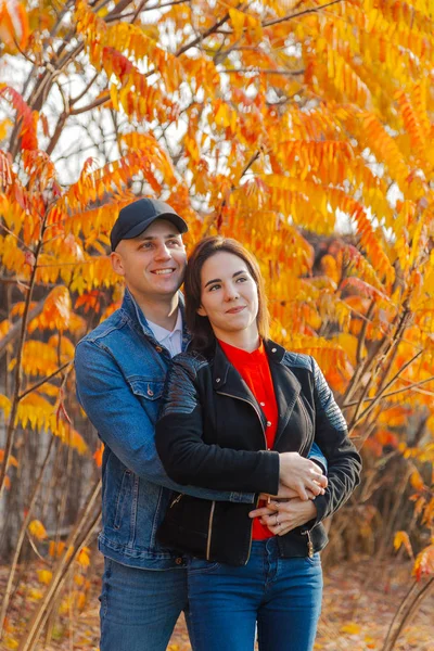 Couple heureux amoureux sur un fond de feuilles jaunes en automne . — Photo