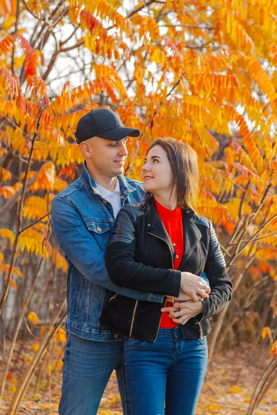 Casal feliz no amor em um contexto de folhas amarelas no outono . — Fotografia de Stock