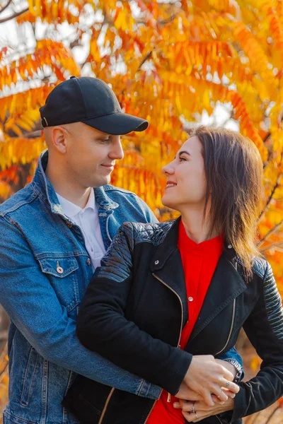 Couple heureux amoureux sur un fond de feuilles jaunes en automne . — Photo