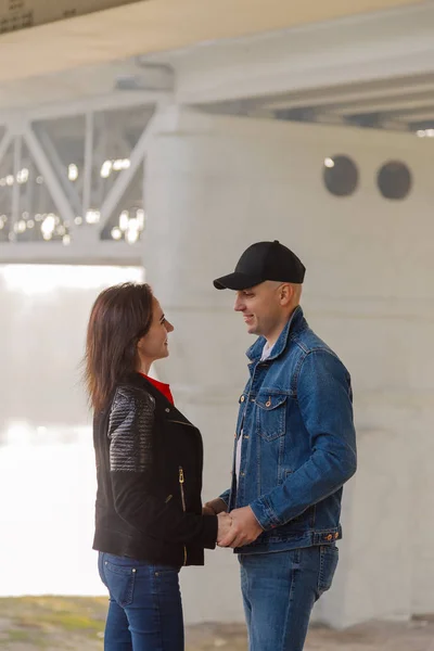 Les amoureux heureux se tiennent sous le pont par une journée ensoleillée . — Photo