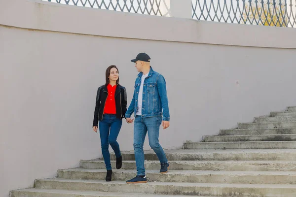 Loving couple walk up the concrete stairs and hold hands. — Stock Photo, Image