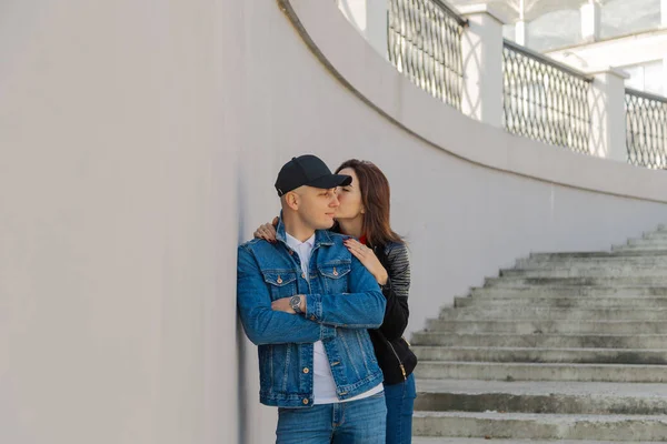 Happy lovers hug on a concrete staircase. — Stock Photo, Image