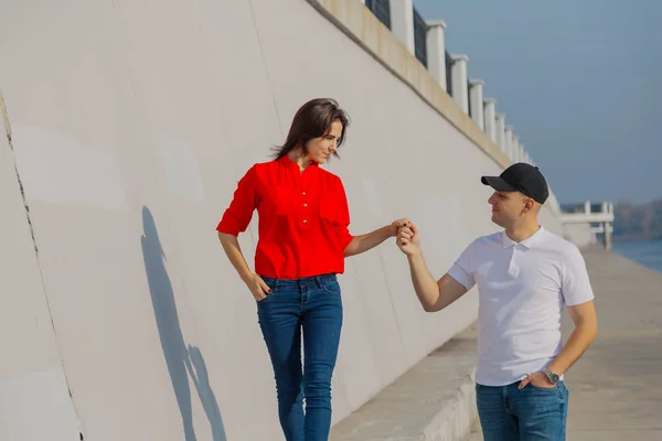 Happy lovers walk along the promenade holding hands. — Stock Photo, Image