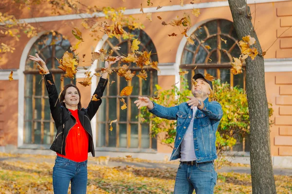 Счастливые влюбленные в желтых листьях осенью в парке . — стоковое фото