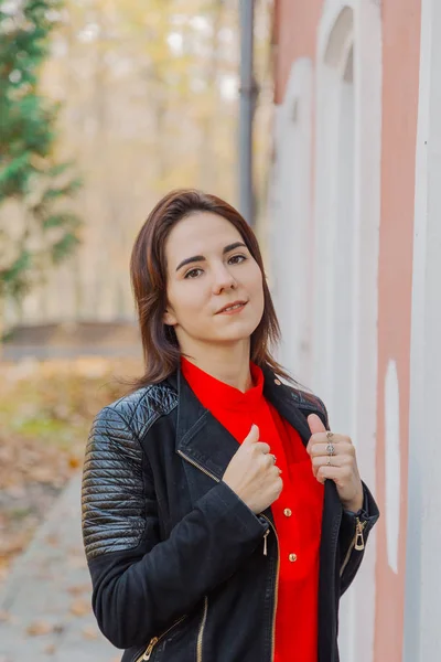 Hermoso retrato de una chica en un parque cerca de la pared . —  Fotos de Stock