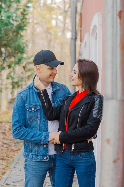 Amantes felices en el parque cerca de la pared. Tiempo en otoño . —  Fotos de Stock