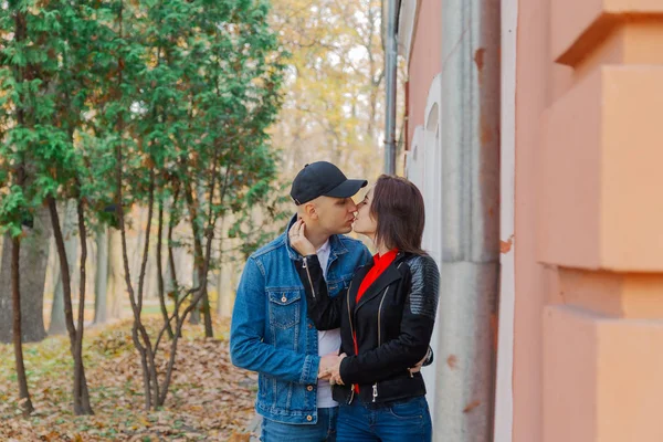 Счастливые любовники в парке у стены. Осенняя погода . — стоковое фото