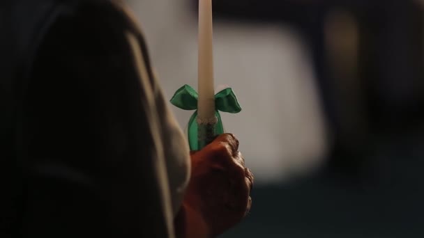Starsza kobieta trzyma płonącą świecę w dłoni.. — Wideo stockowe