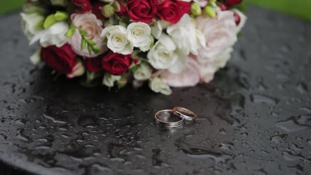 Piękne złote obrączki z eleganckim bukietem ślubnym. — Wideo stockowe
