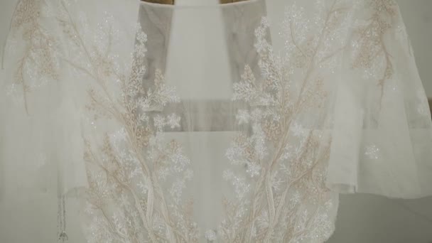 Beautiful modern wedding dress hanging in the house. — Stockvideo