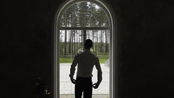 Ділова людина стоїть біля вікна задумливо . — стокове відео