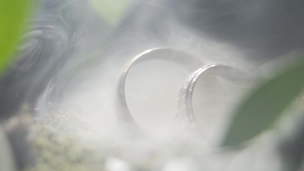 Золотые свадебные кольца в дыму . — стоковое видео