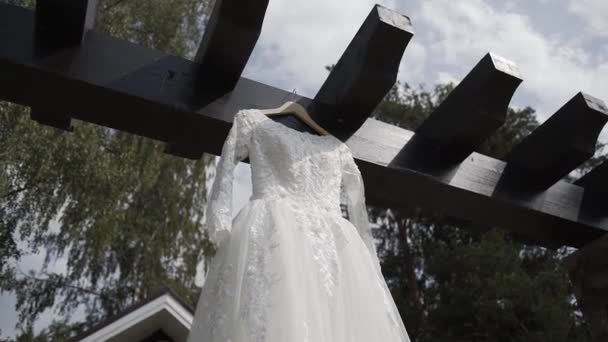 Mooie witte trouwjurk hangend op straat. — Stockvideo
