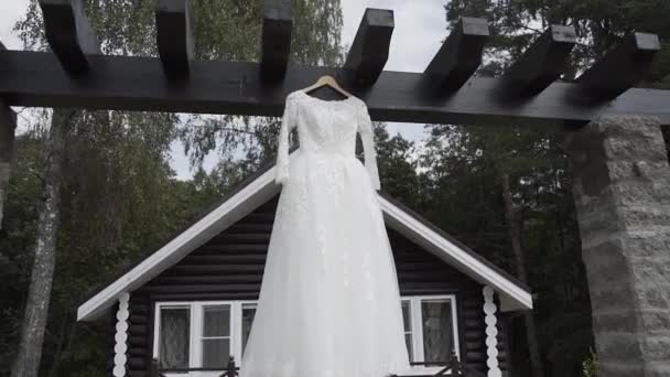 Beautiful white wedding dress hanging on the street. — Stockvideo