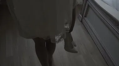 Mutlu gelin elinde ayakkabılarla pencereye doğru yürür..