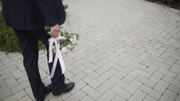 Happy groom comes with a wedding bouquet. — Stock Video