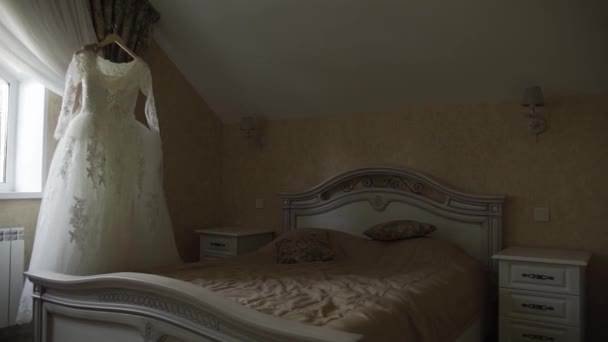 Mariée heureuse tient sa robe de mariée dans ses mains tandis que dans la chambre . — Video