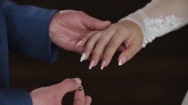 Damat gelini parmağında alyans koyar. Evlilik yüzükler elleriyle. Gelin ve damat nikah yüzükleri değişimi.