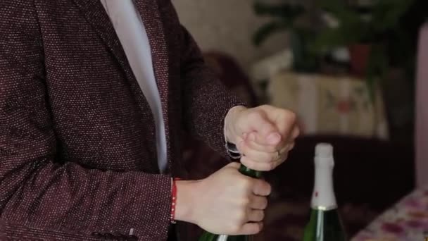 Young man opens a bottle of champagne. — Stock Video