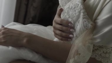 Gelinin elleri gelinliğin üzerinde.