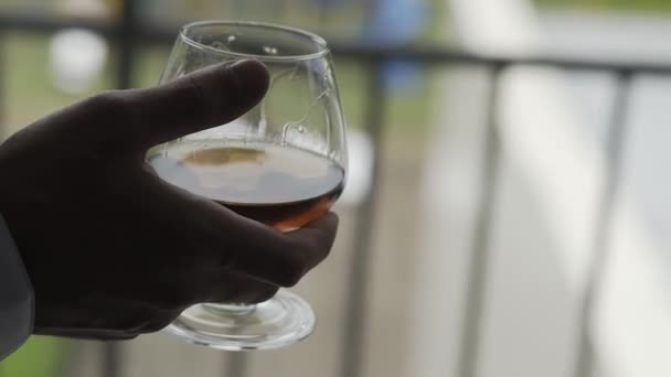 Hombre de negocios con un vaso de whisky junto a la ventana . — Vídeos de Stock