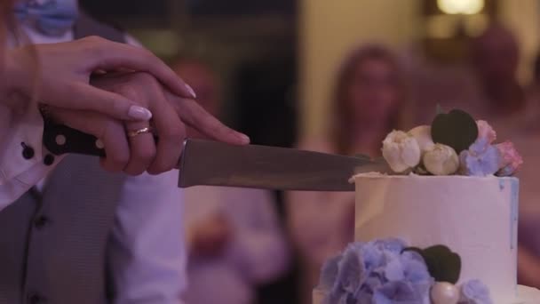 Los recién casados felices cortan un pastel de bodas en una celebración . — Vídeo de stock