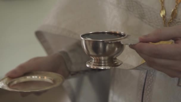 Los sacerdotes bautizan a mano una copa de vino. — Vídeo de stock