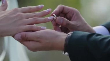 Damat gelini parmağında alyans koyar. Evlilik yüzükler elleriyle. Gelin ve damat nikah yüzükleri değişimi.
