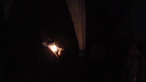 Seorang pria menyalakan kembang api untuk liburan . — Stok Video