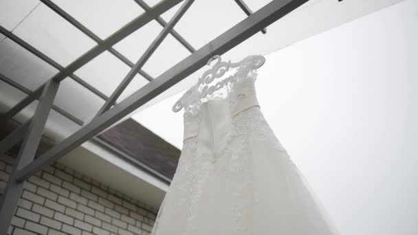 Gyönyörű fehér esküvői ruha lóg az utcán. — Stock videók