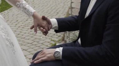 Mutlu yeni evliler düğün gününde el ele tutuşur..