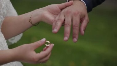Damat gelini parmağında alyans koyar. Evlilik yüzükler elleriyle. Gelin ve damat nikah yüzükleri değişimi.