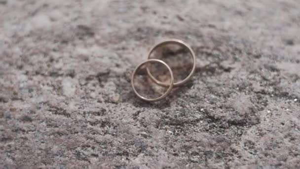 Beautiful golden wedding rings on a stone. — Stock Video