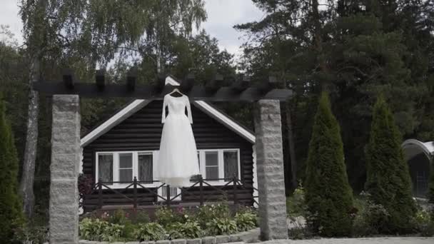 Krásné bílé svatební šaty visí na ulici. — Stock video